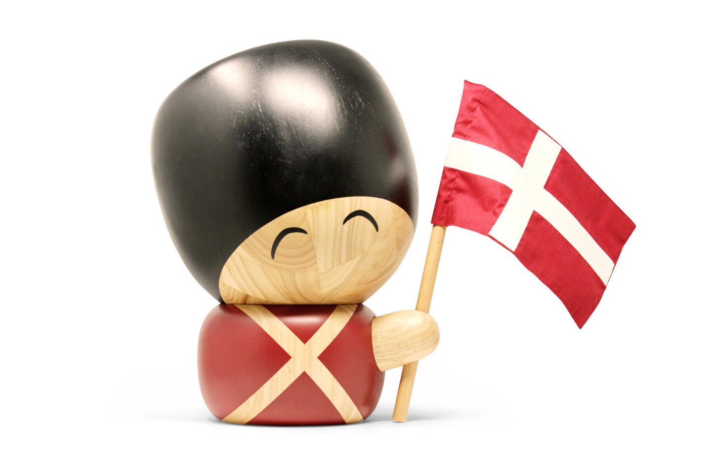Knud den store træfigur. Står med smilende ansigtsudtryk og bomuldsflag i hånden.